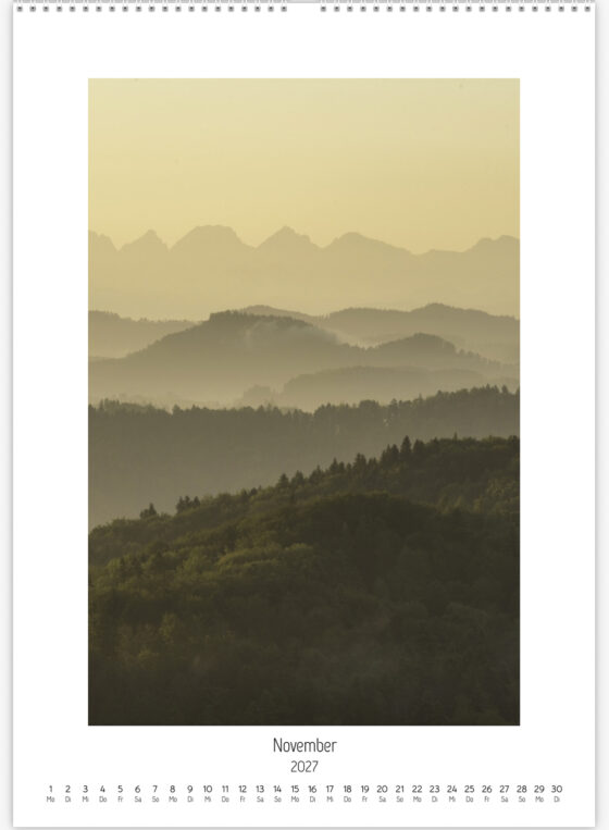 Blick aus dem Zürcher Oberland Richtung Churfirsten mit mehreren Berg- und Hügelebenen in Dunst und warmem Morgenlicht.